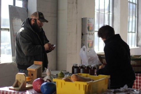 A vendor at the Lexington Farmers Market, which is now open during the winter months at an indoor location, writes down an order for one of his customers.