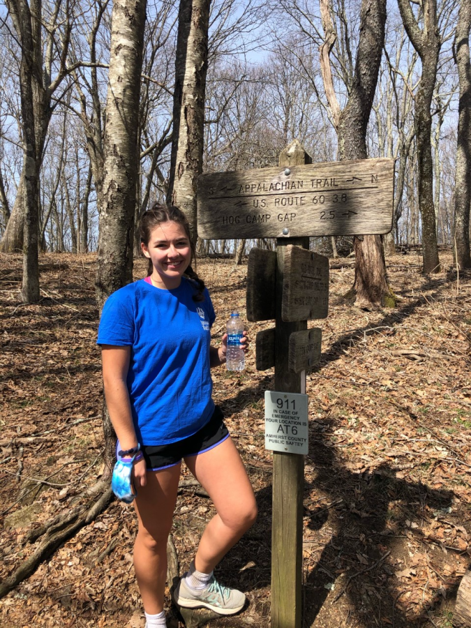 Adele Roulston, ‘24, stands by a sign on the Appalachain trail during Women in the Outdoors Month. Photo courtesy of Ashley Hancox, ‘21.