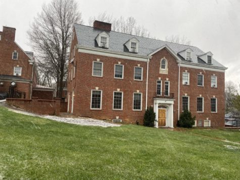 Pi Kappa Alpha house, a brick building with many windows, sitting on a tilted grassy hill.
