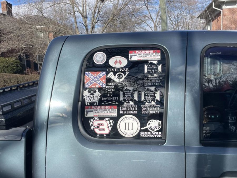 A trucks back passenger window is adorned with Confederate reenactor stickers.