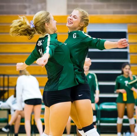 The Stone sisters share a chest bump at a high school volleyball match. 