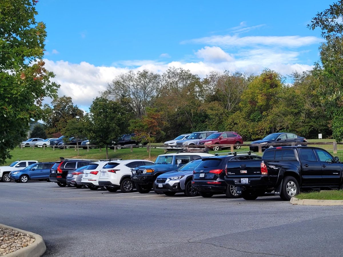Parked cars line the grass outside of third-year parking, a result of overflow. 