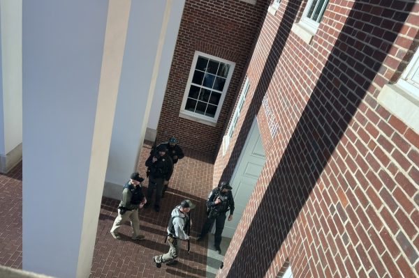 Law enforcement officers armed with rifles enter the Center for Global Learning on Wednesday, Nov. 1, during a campus-wide lockdown.
