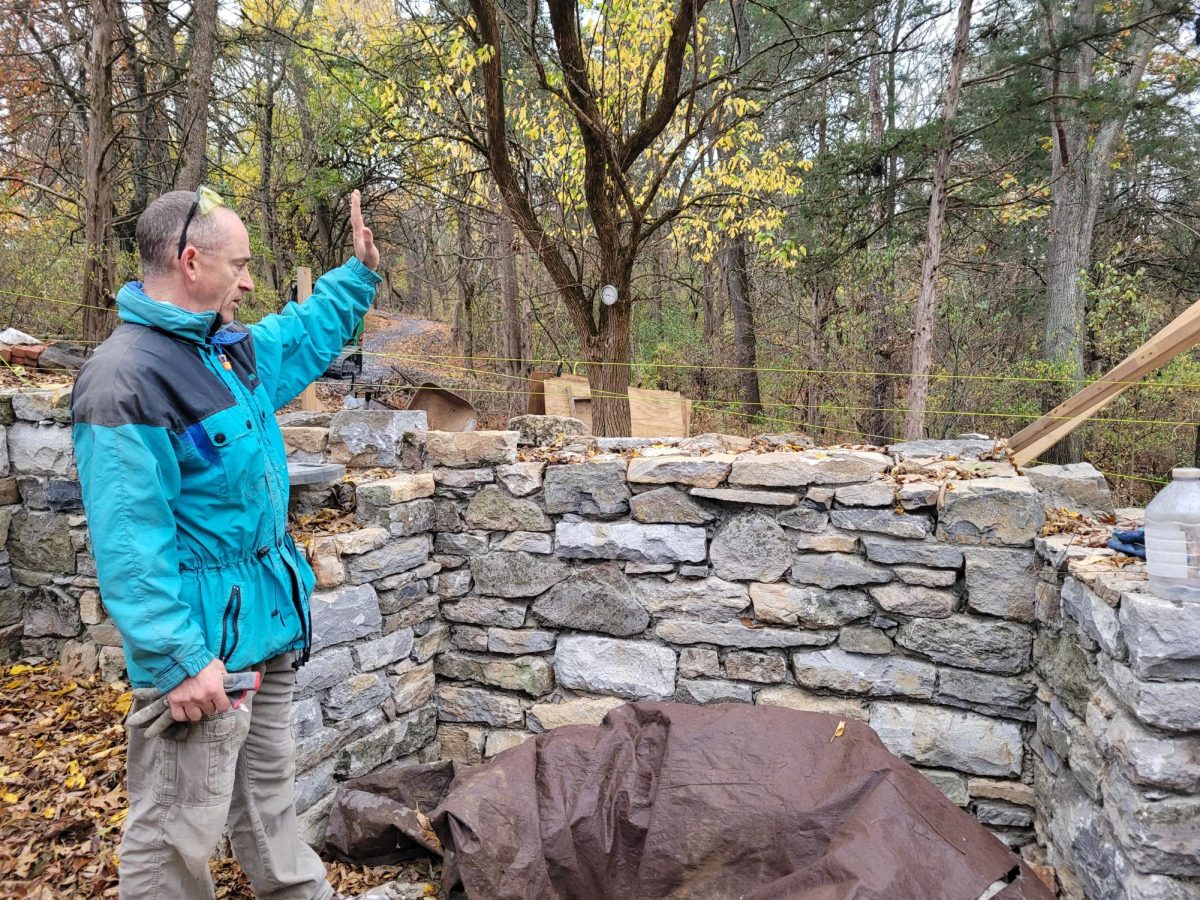 Jesse Friedrichs, co-owner of New Dimension Masonry, explains how stones are cut and placed to replicate the 18th-century structure.