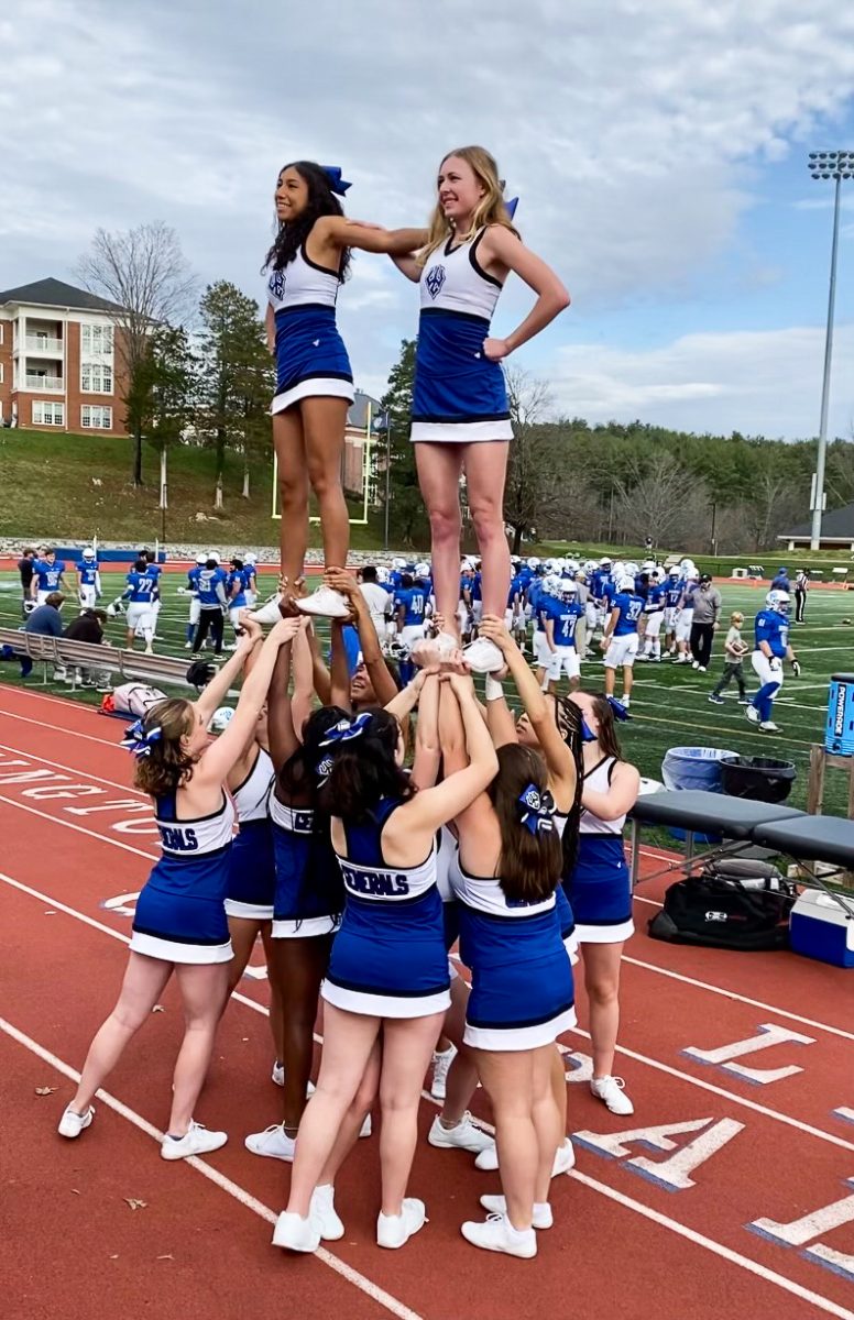 The 2022 club cheer team performs a stunt on the sideline of a W&L football game. Photo courtesy of Catherine McCurdy